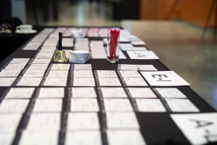 A picture of the registration counter with name tags on it, a bell and a glass full of pencils