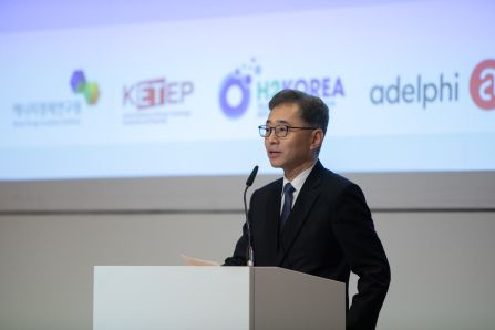 Close up of speaker presenting, Logos of KETEP, H2KOREA and adelphi in the background visible