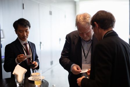 three people looking at the business cards, that they just exchanged