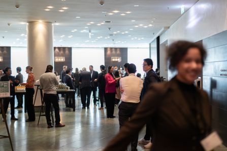 Wide shot of people chatting over coffee, a person smiling in the foreground