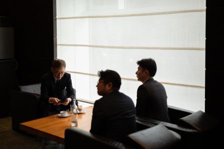 Three people seated, networking over a coffee