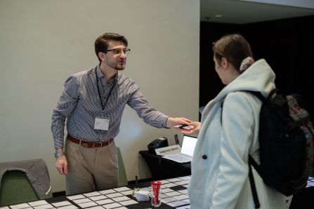 Registration personnel handing out a name tag to a guest