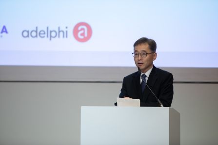 speaker presenting, Logo of adelphi in the background visible